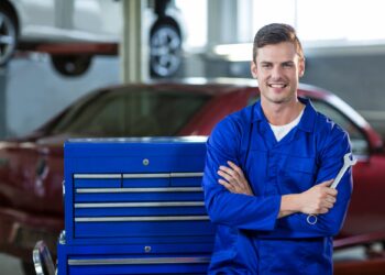 Portrait of mechanic standing with arms crossed in repair garage