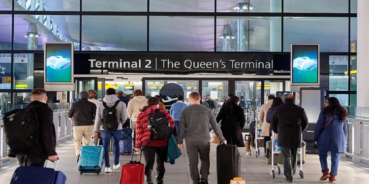 Passengers with luggage arriving at London Heathrow Airport Terminal 2.